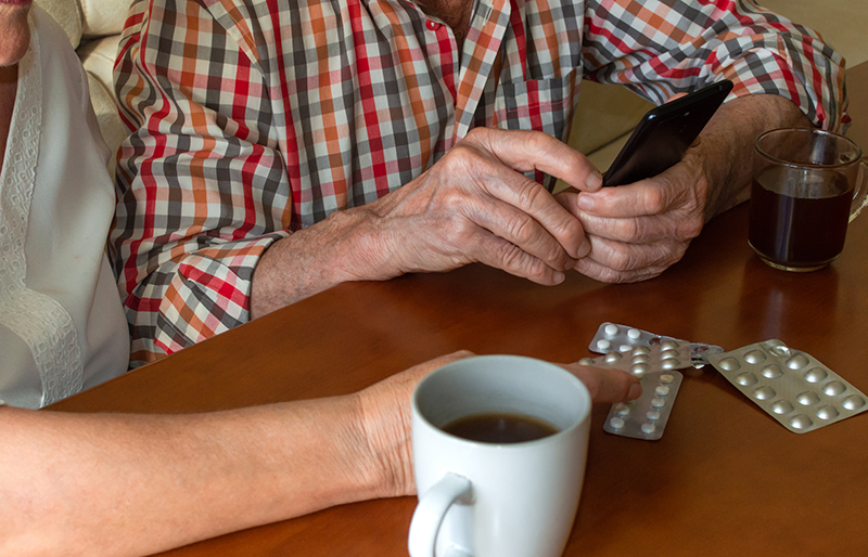 Elderly couple searches for medical information on a smartphone.