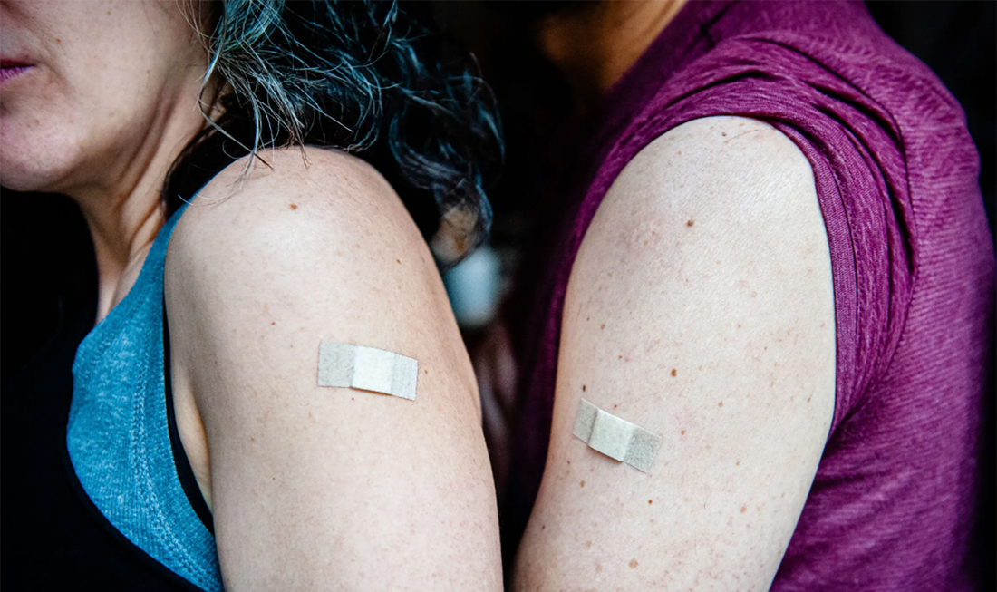 Newly vaccinated patients with band-aids on their arms.