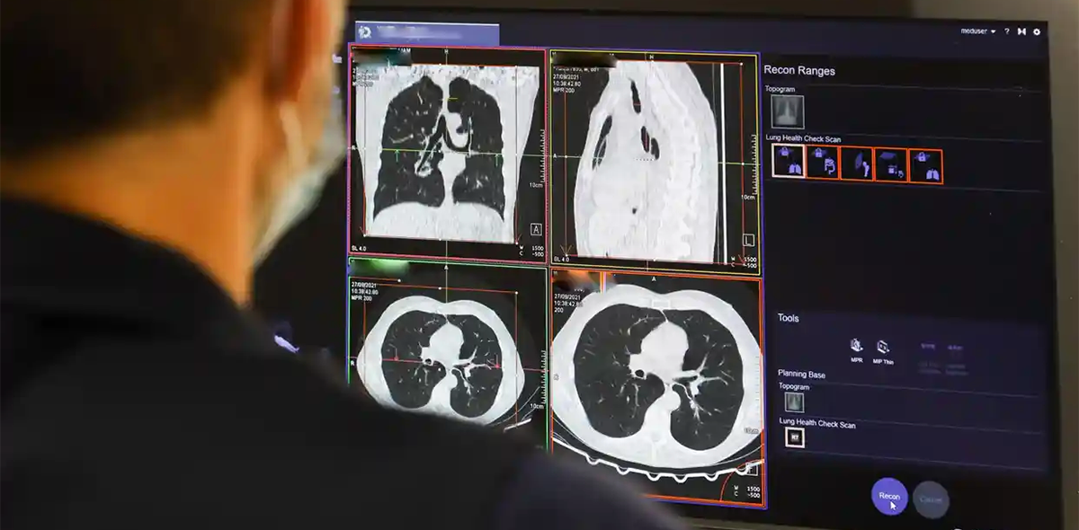 A clinical staff member looks at the results of a lung scan.