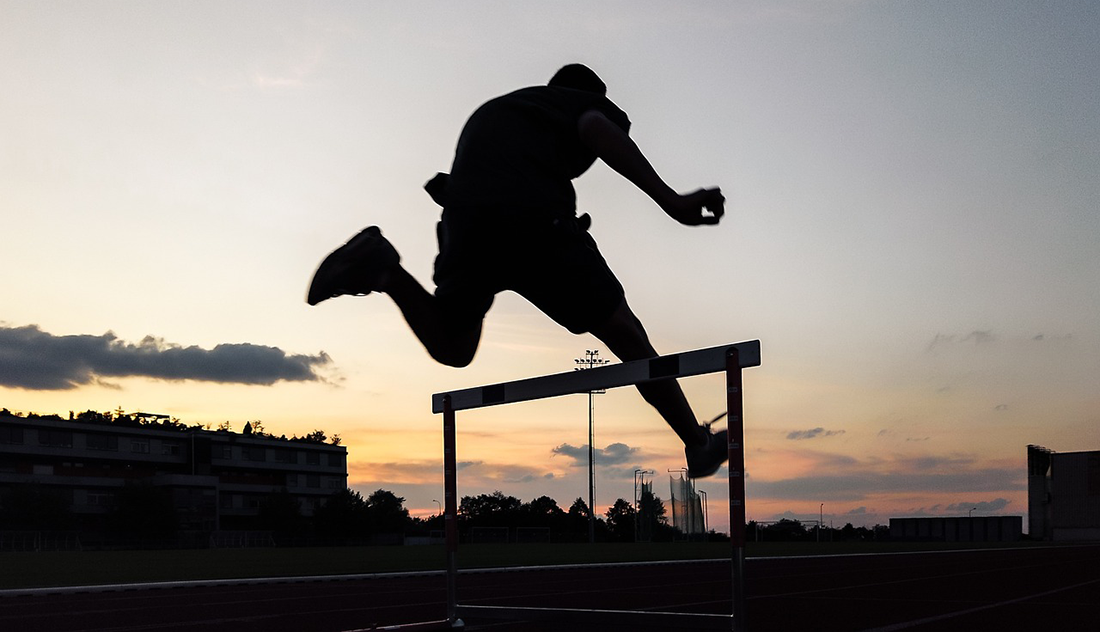 A person jumping over a hurdle.