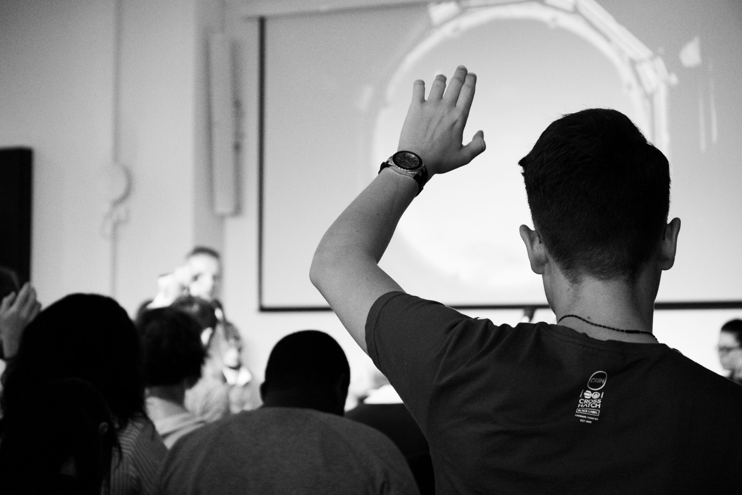A person raising their hand during a presentation.