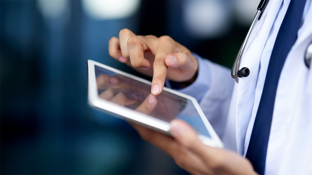 Healthcare professional works on a.n electronic tablet.