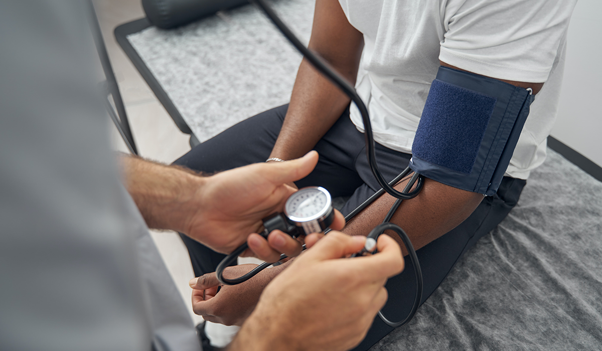 A patient has their blood pressure checked by a healthcare provider.