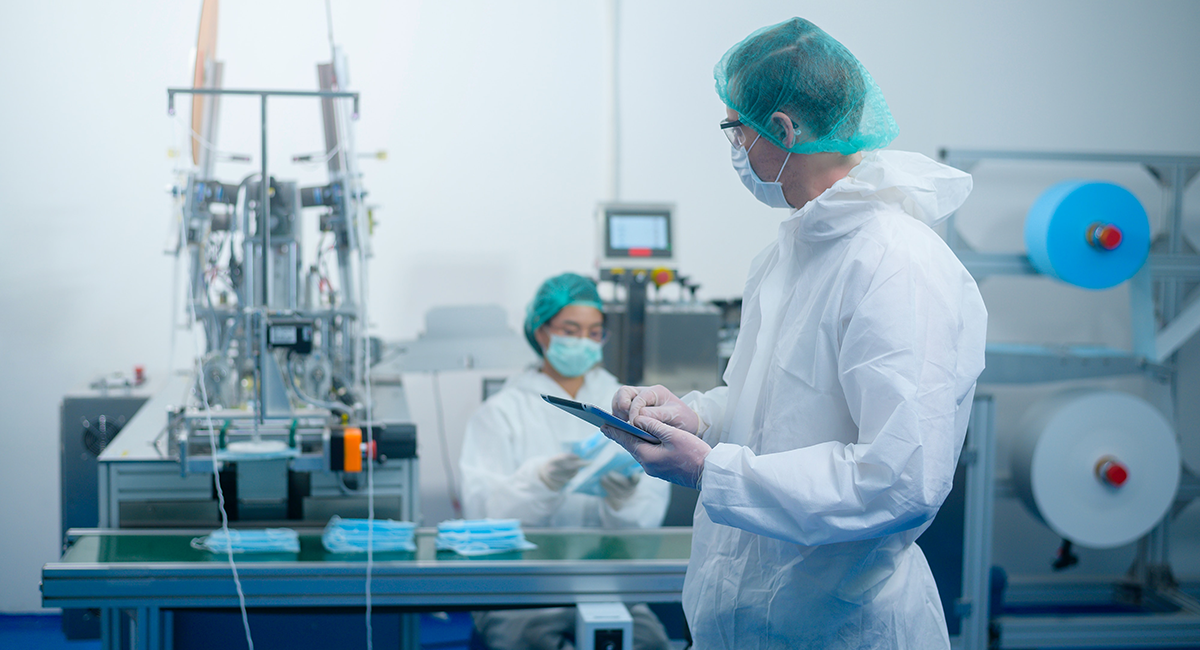 Masked workers in a medical device production facility.