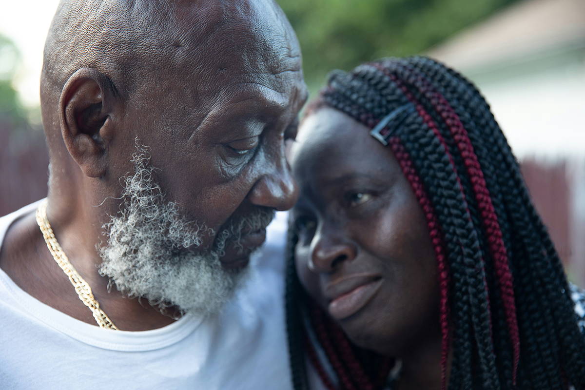 A Black couple embraces and looks at each other.